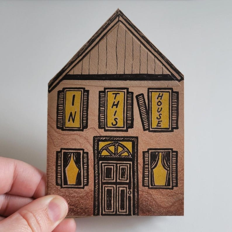 Pode incluir: Uma ilustra&ccedil;&atilde;o desenhada &agrave; m&atilde;o de uma casa com telhado castanho e janelas amarelas. As janelas t&ecirc;m sinais que dizem "In This House".