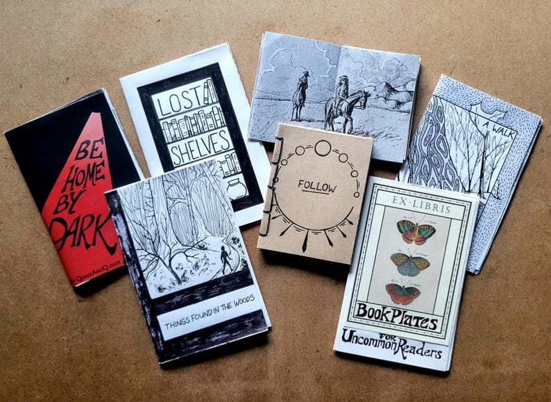 May include: A collection of eight small, handmade books with various titles and illustrations. The books are bound with different colored covers and feature black and white drawings. The titles include "Lost Shelves", "Be Home By Dark", "Things Found In The Woods", "Follow", "Ex-Libris", "BookPlates For Uncommon Readers", and "A Walk".