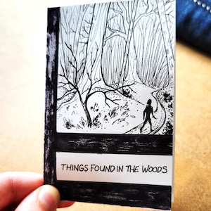 May include: Black and white illustration of a person walking on a path through a forest. The text "THINGS FOUND IN THE WOODS" is at the bottom of the image.