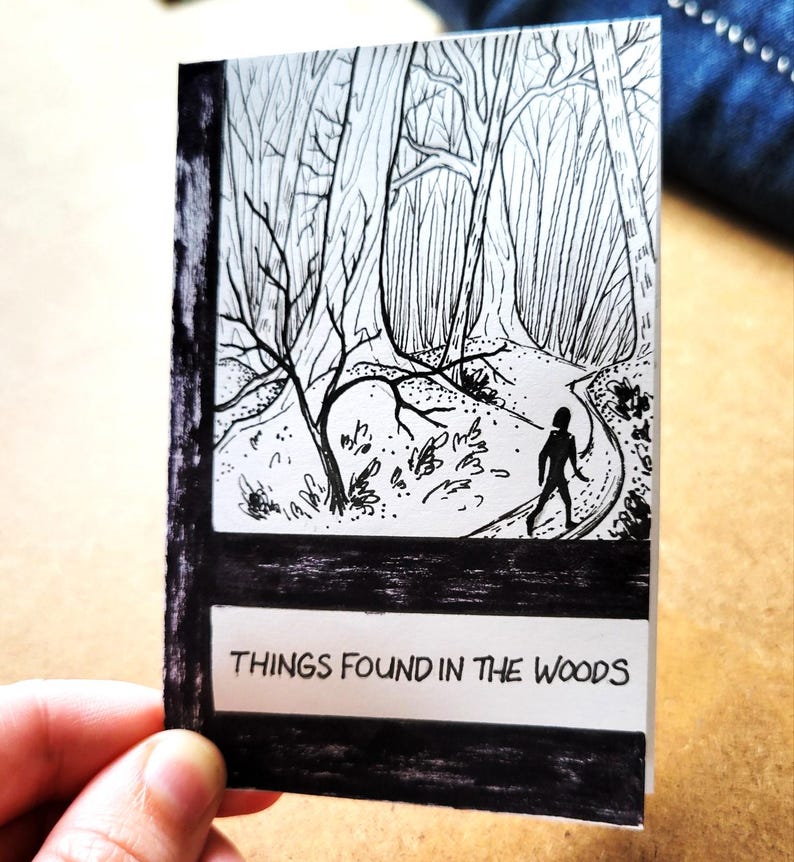 May include: Black and white illustration of a person walking on a path through a forest. The text "THINGS FOUND IN THE WOODS" is at the bottom of the image.