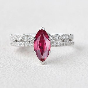 May include: A silver ring set with a marquise-shaped ruby gemstone and a delicate diamond band.