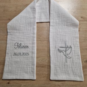May include: White baptismal stole with embroidered details. The stole features the name "Felicien" and the date "26.01.2025" in script. A dove and cross design is embroidered on the opposite end. The stole is made of a textured fabric.