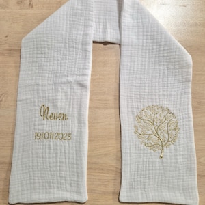 May include: White scarf with a textured weave. The scarf features embroidered text that reads "Never" above the date "19/01/2025" and a gold tree design. The scarf is made of a soft, lightweight fabric.