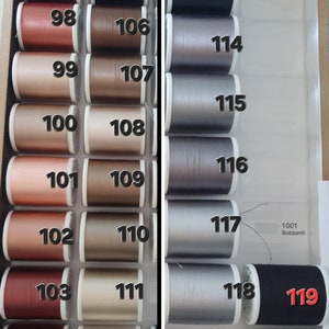 May include: A selection of sewing thread spools in various colors, arranged in a divided storage box. The spools are labeled with numbers from 97 to 120, with shades ranging from red and brown to silver and black. The text "1001 Bobbinfil" is also visible.