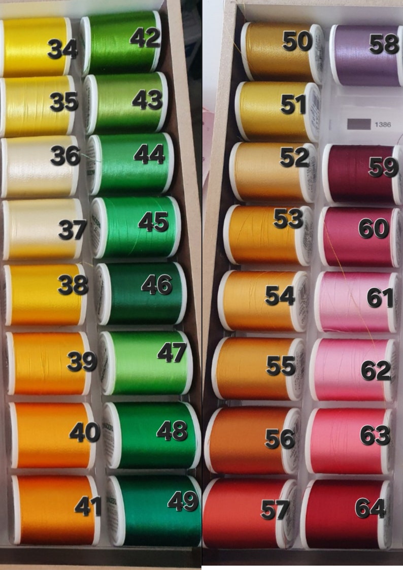 May include: A wooden box filled with spools of thread in various colors. The thread colors range from yellow and green to orange, red, and purple. Each spool is labeled with a number from 34 to 64.