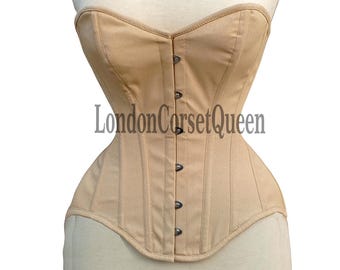 Könnte beinhalten: Ein beiger, trägerloser Korsett mit Satin-Finish und einer Reihe silberner Knöpfe auf der Vorderseite. Das Korsett befindet sich auf einer weißen Schaufensterpuppe. Der Text "LondonCorsetQueen" ist auf der Vorderseite des Korsetts aufgedruckt.