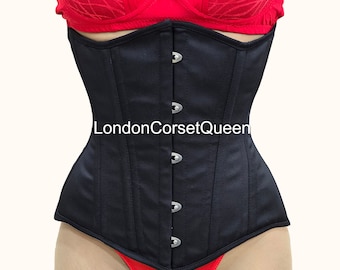 May include: A black corset with a busk closure and steel boning. The corset has a satin finish and is shown with a red bra and red underwear.