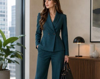 May include: A dark teal double-breasted blazer with a shawl collar and two buttons, paired with matching wide-leg trousers featuring a center crease. The ensemble is accessorized with a structured black leather handbag and black pointed-toe shoes.
