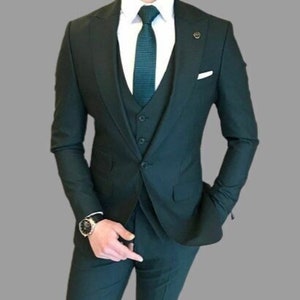 Könnte beinhalten: Ein dunkelgrüner dreiteiliger Anzug mit einem weißen Hemd und einer dunkelgrünen gemusterten Krawatte.