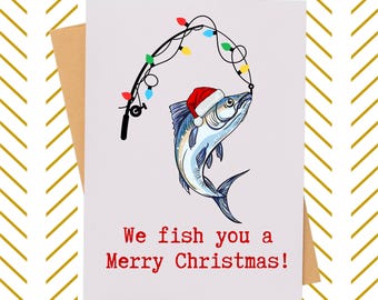 May include: A Christmas card featuring a cartoon fish wearing a Santa hat, hooked by a fishing rod strung with colorful Christmas lights. The card reads "We fish you a Merry Christmas!" in red text.