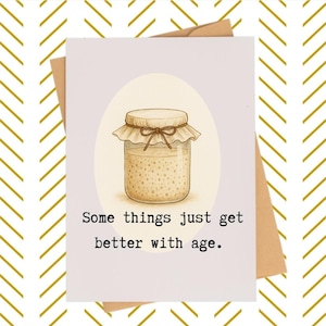 May include: Greeting card with a watercolor illustration of a jar with a beige lid and a bow. The card has the text "Some things just get better with age." The card is on a white background with a brown envelope.