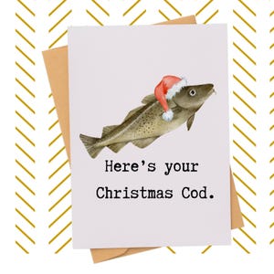 May include: A Christmas card with a watercolor illustration of a cod wearing a Santa hat. The card reads "Here's your Christmas Cod." The card is on a brown envelope, with a gold and white chevron pattern in the background.