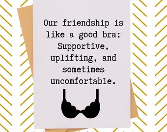May include: A greeting card with the text "Our friendship is like a good bra: Supportive, uplifting, and sometimes uncomfortable." The card features a black bra illustration and is set against a brown envelope and a gold and white chevron pattern.