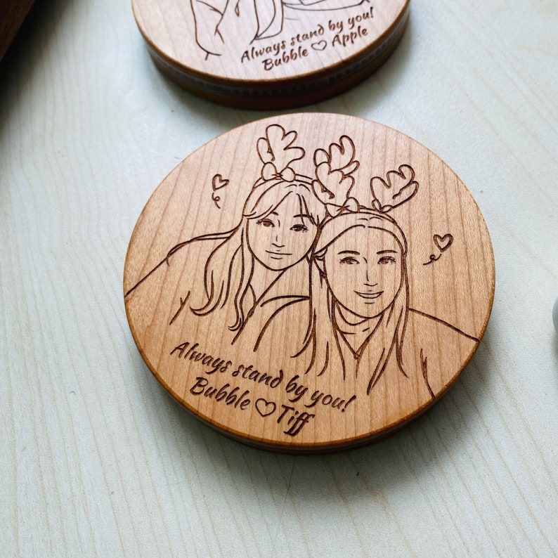 A wooden wireless charger with an engraved photo of two women on it