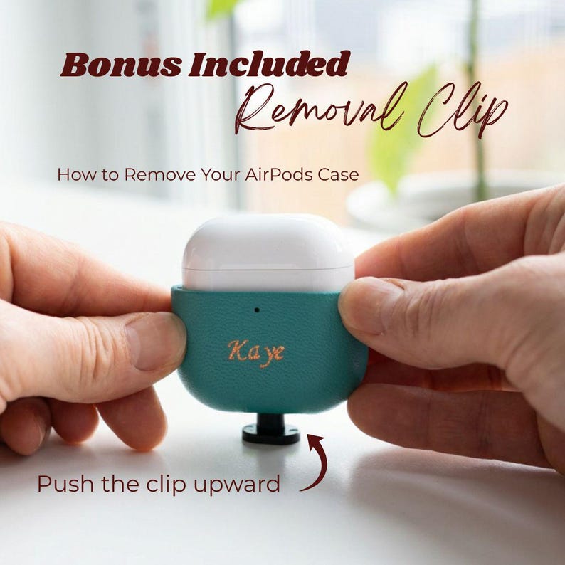 Shown with the included removal clip for easy AirPods installation and removal on a white desk.