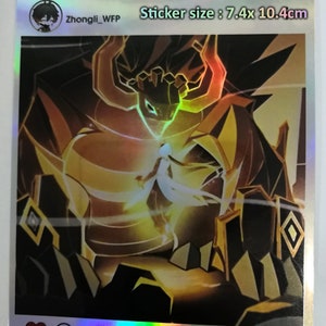 May include: Holographic sticker featuring a detailed illustration of a character with a dragon-like form and a figure in white. The sticker is 7.4 x 10.4 cm in size. The artwork has gold, black, and orange tones.