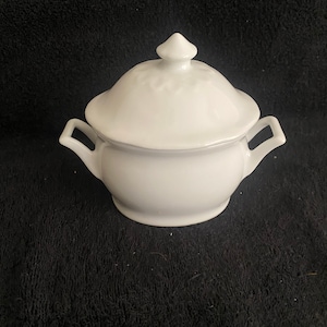 Puede incluir: Azucarero de porcelana blanca con tapa y dos asas. El tazón tiene un diseño simple y es perfecto para servir azúcar.