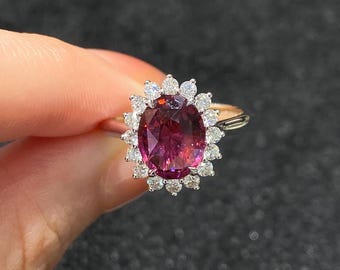 Peut inclure: Une bague en or ornée d'une grosse pierre précieuse rose foncé de forme ovale, entourée d'un halo de petites pierres précieuses claires. Le design de la bague est élégant et accrocheur, adapté aux occasions spéciales.