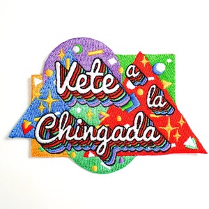 May include: A colorful embroidered patch with the text "Vete a la Chingada" in a rainbow font. The patch is made up of geometric shapes in various colors, including red, green, blue, and yellow.