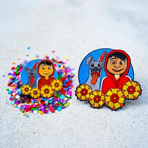 May include: Embroidered patches featuring a boy in a red hoodie with a dog, set against a blue background. The patches are surrounded by yellow and orange flowers and colorful confetti.