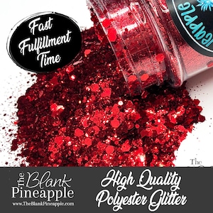 May include: A close-up of a red glitter, with a jar of the glitter spilling out onto a white surface. The jar has a black label with the text "The Blank Pineapple" and "High Quality Polyester Glitter".