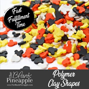 May include: A variety of colorful polymer clay shapes in the form of Mickey Mouse ears. The shapes are scattered on a white surface. The text "Fast Fulfillment Time" is visible in the top left corner of the image. The text "The Blank Pineapple" is visible in the bottom left corner of the image. The text "Polymer Clay Shapes" is visible in the bottom right corner of the image.
