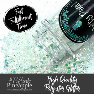 Puede incluir: Un frasco transparente de purpurina verde y blanca con el texto "Pineapple glitters" y "Salty Pear" en la etiqueta. El frasco está derramando purpurina sobre una superficie blanca. El texto "Fast Fulfillment Time" está en un círculo negro en la esquina superior izquierda de la imagen. El texto "High Quality Polyester Glitter" está en un rectángulo negro en la parte inferior de la imagen.