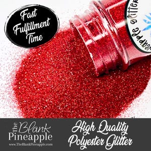 May include: A red glitter jar spilling out onto a white surface. The jar is labeled "The Blank Pineapple" and "High Quality Polyester Glitter".