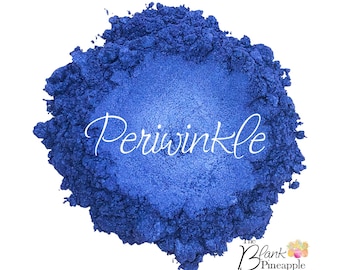 以下が含まれることがあります： 輝く効果のある、ペリウィンクル色の粉末の山。「Periwinkle」の文字が筆記体で粉末の上に書かれています。The Blank Pineapple & Pineapple Glittersのロゴが右下にあります。
