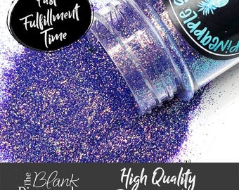 May include: A clear plastic jar filled with iridescent purple glitter. The jar has a black label with a pineapple logo and the text "The Blank Pineapple" and "High Quality Polyester Glitter".
