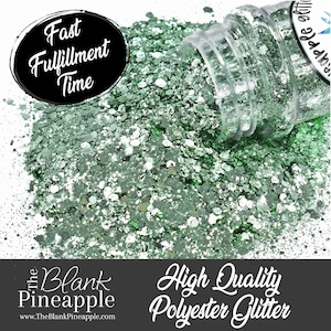May include: A clear plastic bottle spills out green and silver glitter. The glitter is scattered across a white surface. Text on the image includes "Fast Fulfillment Time" and "High Quality Polyester Glitter."