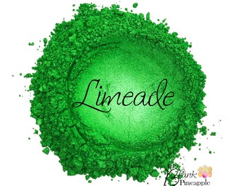 May include: A close-up of a bright green powder with the word "Limeade" written in black cursive lettering. The powder is in a pile on a white background.