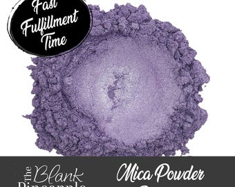 May include: A close-up of a pile of purple mica powder pigment. The powder is shimmery and has a metallic sheen. The text "Mica Powder Pigment" is visible below the pile of powder.
