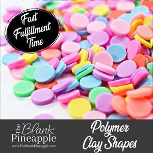 May include: Assortment of colorful polymer clay shapes in various pastel colors, including pink, blue, green, yellow, and orange. The clay shapes are small and round, perfect for crafting and decorating.