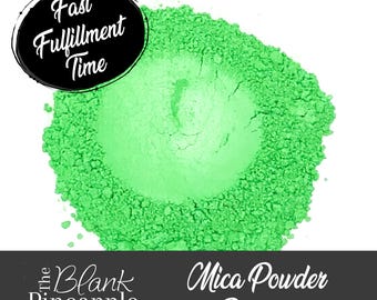 May include: A close-up of a bright green mica powder pigment. The powder is in a pile and has a smooth, even texture.