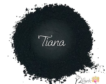 以下が含まれることがあります： 白い筆記体で「Tiana」と書かれた濃い黒色の粉末。粉末は円形で、右下隅には「The Blank Pineapple & Pineapple Glitters」と書かれたロゴがあります。