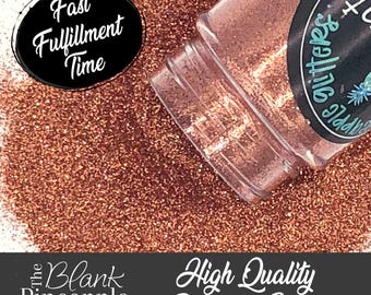 May include: A close-up of a jar of copper glitter. The jar is labeled "The Blank Pineapple Glitter". The glitter is a fine, shimmery copper color. The text "Fast Fulfillment Time" is visible in the background.