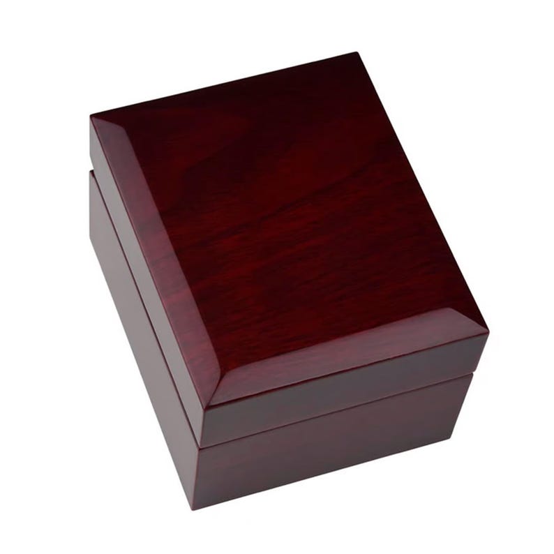 May include: A rectangular, closed wooden box with a high-gloss, dark reddish-brown finish. The box has a hinged lid and a clean, minimalist design, suitable for jewelry or small keepsakes. The wood grain is visible through the polished surface.
