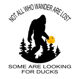 May include: A black silhouette of Bigfoot walking through a forest, holding a yellow rubber ducky. The text "Not all who wander are lost. Some are looking for ducks." is written around the image.