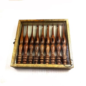 May include: A set of ten wooden crochet hooks in a wooden box with a clear lid. The hooks are different sizes and are labeled with numbers.