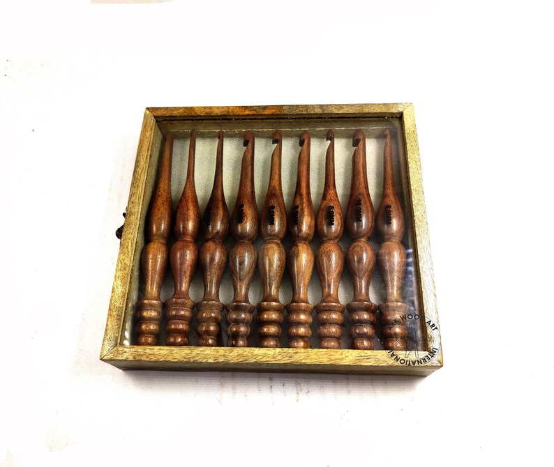 May include: A set of ten wooden crochet hooks in a wooden box with a clear lid. The hooks are different sizes and are labeled with numbers.