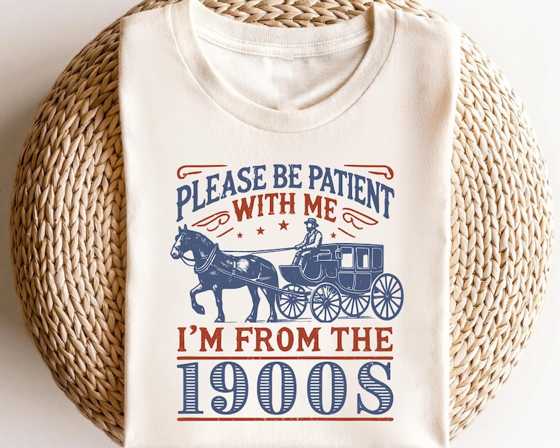 Pu&ograve; includere: Maglietta bianca con un design grafico blu e rosso. Il grafico presenta una carrozza trainata da un cavallo con il testo "Per favore, sii paziente con me, sono degli anni 1900".