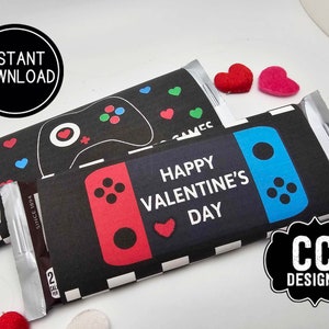 May include: Two printable chocolate bar wrappers with a video game theme. The wrappers feature a black background with a red and blue video game controller design. The text "Happy Valentine's Day" is printed on the wrappers.