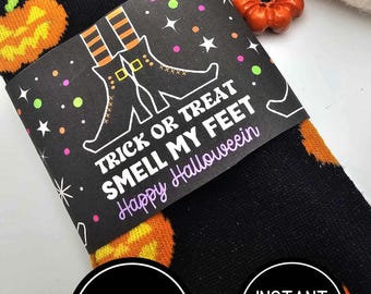 Puede incluir: Calcetines negros con diseños de calabazas naranjas y una etiqueta negra y blanca que dice "Trick or Treat Smell My Feet Happy Halloween".