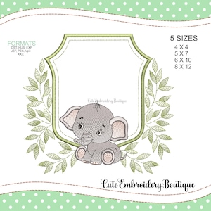 Puede incluir: Diseño bordado de un lindo elefante gris con orejas rosas que asoman detrás de un marco verde de hojas. El marco tiene un espacio en blanco para la personalización. El diseño está disponible en cinco tamaños: 4x4, 5x7, 6x10 y 8x12 pulgadas.