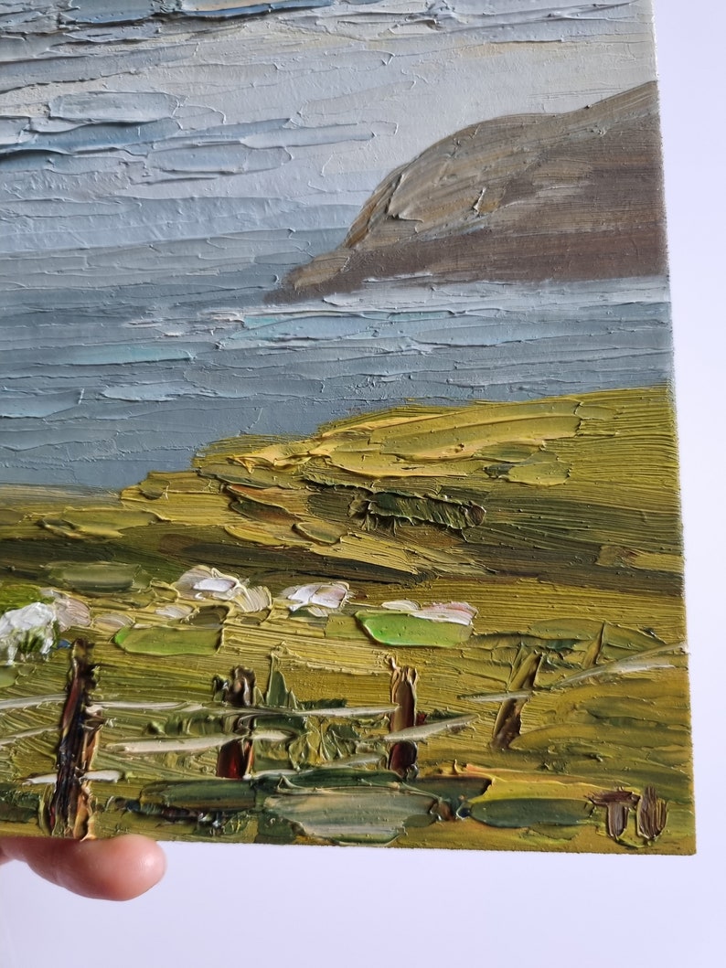 Pode incluir: Pintura a &oacute;leo de uma paisagem costeira, com estilo impasto. A obra retrata um mar, uma fal&eacute;sia rochosa e um primeiro plano gramado. A paleta de cores inclui tons de azul, verde, castanho e cinza.