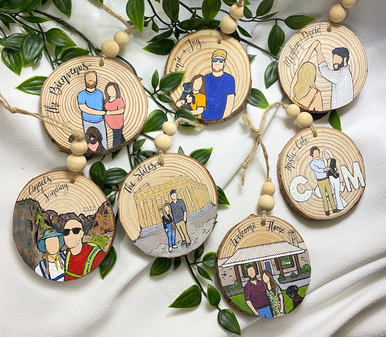 May include: Set of ten round wooden ornaments with painted images and text. The ornaments feature couples, dogs, and scenes from different locations. The text on the ornaments includes names, dates, and locations.
