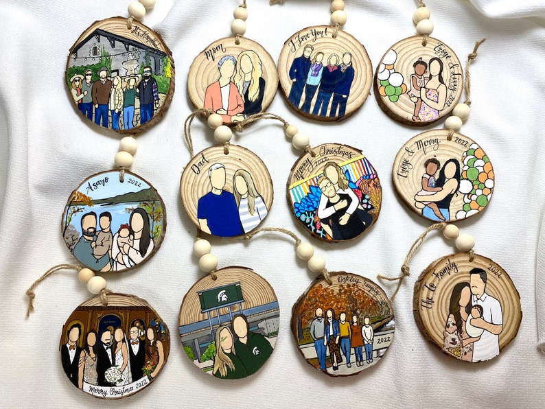 May include: A set of 10 round wooden ornaments with painted illustrations of families and the words "Mom", "Dad", "Love You!" and "Merry Christmas 2022".