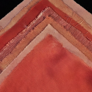 May include: A collection of fabric swatches in various shades of orange and brown, arranged in a triangular pattern. The swatches are made of different types of fabric, including linen, cotton, and silk.