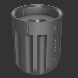 Op de afbeelding: Een grijs cilindrisch object met verticale groeven en het woord "Cubic" in reliëf aan de zijkant. De bovenkant heeft een cirkelvormige opening en de onderkant is afgerond. Het ontwerp suggereert een functioneel, mogelijk mechanisch onderdeel.